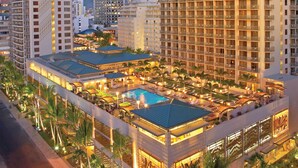 A hotel with multiple high-rise buildings, a swimming pool, and outdoor seating areas.