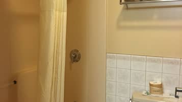 A bathroom with a bathtub, toilet, and shower curtain.
