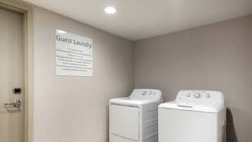 A laundry room with two white washing machines and a sign indicating it's for guest use only.