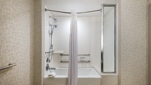 Une salle de bain moderne équipée d’une douche, d’une baignoire et d’un espace de douche vitré.