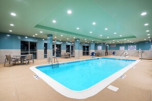 Ein Poolbereich mit klarem Wasser, deutlicher Tiefenmarkierung und Hinweisschildern für den Ausgang.