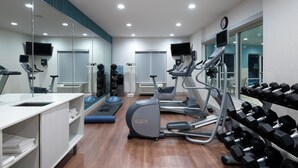 A modern gym with cardio equipment, weightlifting area, and mirrors. - Holiday Inn Express & Suites Florence I-95 & I-20 Civic Ctr by IHG (Florence)