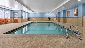 An indoor swimming pool with a clear water surface, surrounded by beige tiled walls and a blue accent wall. - Holiday Inn Express Hotel & Suites Freeport by IHG (Freeport)