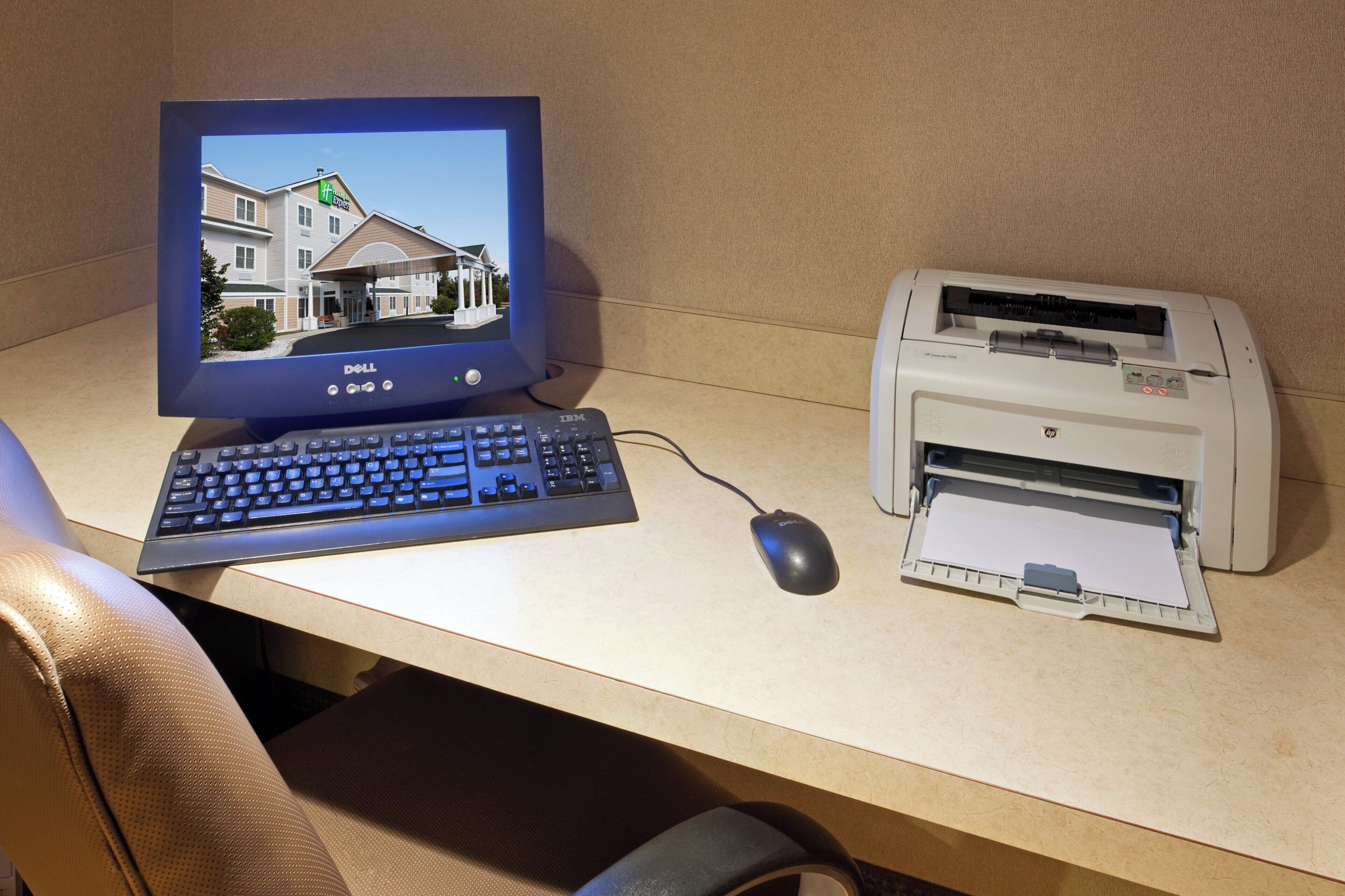 Un ordinateur installé sur un bureau, comprenant un écran, un clavier, une souris et une imprimante.