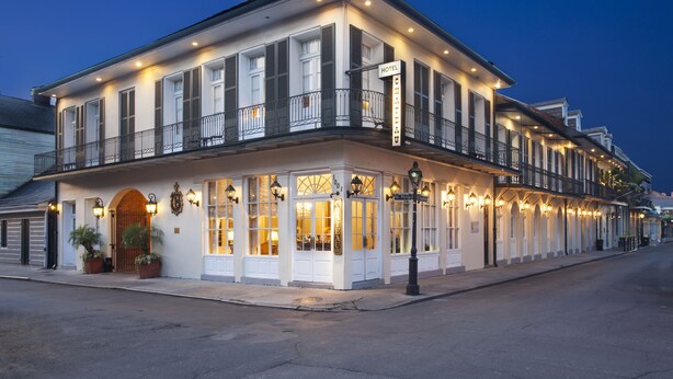 A hotel with a balcony, large windows, and a sign indicating it is a hotel. - Chateau Hotel (New Orleans)