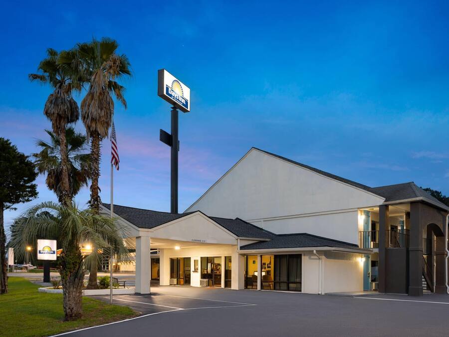 A Holiday Inn Express hotel with a clear sky and palm trees in the foreground.