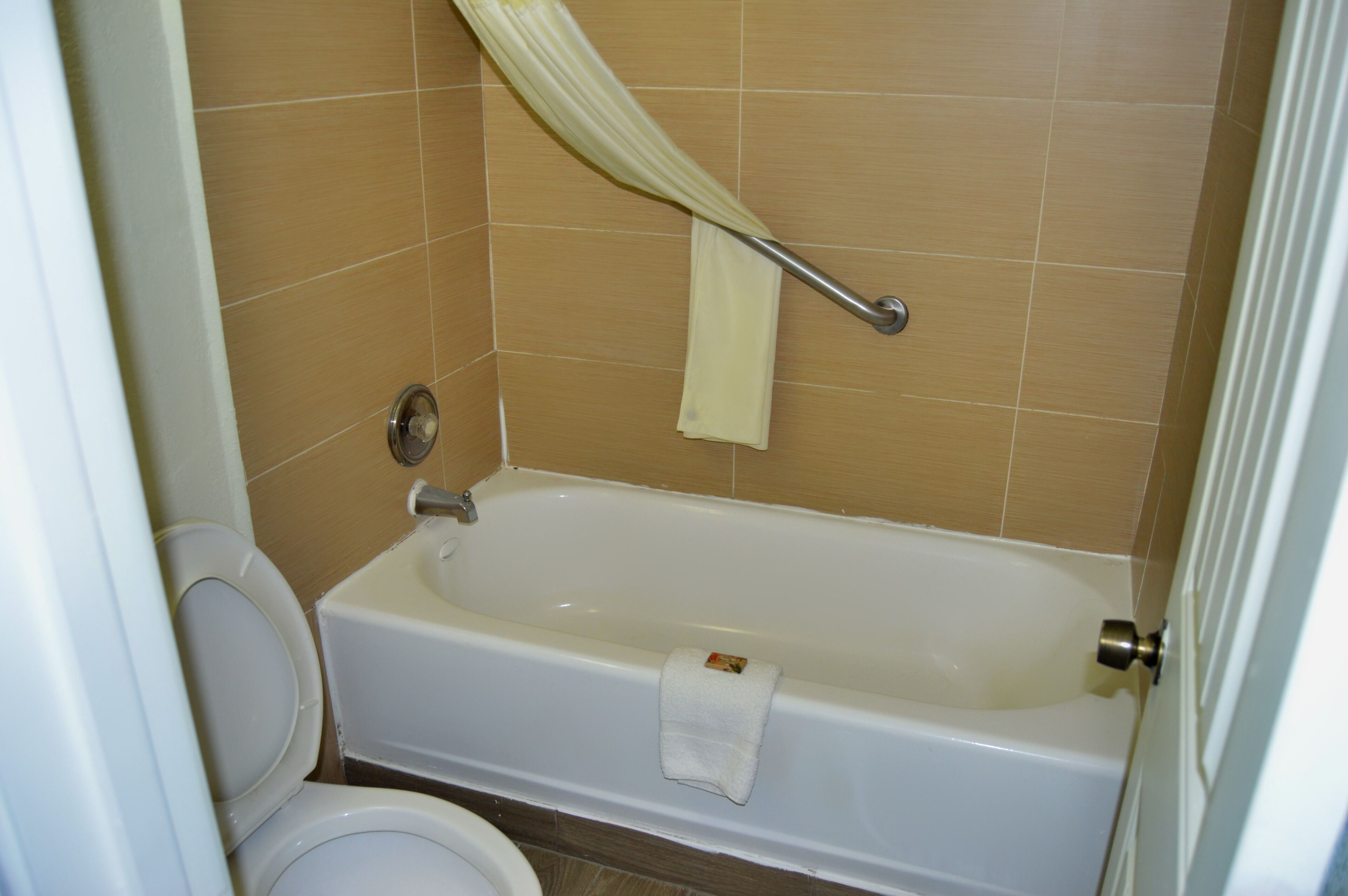 Une salle de bain avec une baignoire, des toilettes et un rideau de douche.