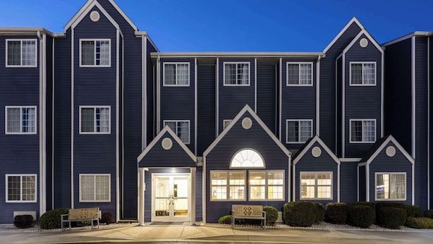 A multi-story hotel with a symmetrical facade, large windows, and a central entrance with a welcoming archway. - Microtel Inn & Suites by Wyndham Dover (Dover)