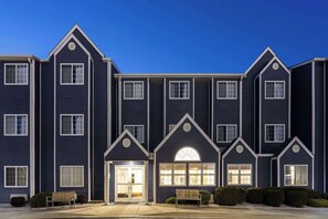 A multi-story hotel with a symmetrical facade, large windows, and a central entrance with a welcoming archway.