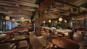 A modern restaurant interior with wooden tables and chairs, hanging plants, and a bar area. - 1 Hotel Seattle (Seattle)