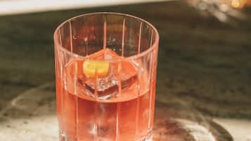 Un vaso con una bebida sobre una superficie de mármol.