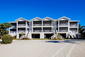 A multi-story hotel with balconies, a central courtyard, and a sandy ground.