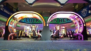 A casino with illuminated arches labeled "LUCKY THIEVES HERE" and various slot machines.