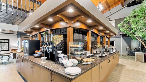 A modern kitchen with a central island, built-in appliances, and a variety of utensils and cookware. - Heartland Inn & Suites, SureStay Collection by Best Western (Park Rapids)