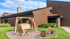A modern house with a swing set and a rocking chair in the yard. - Heartland Inn & Suites, SureStay Collection by Best Western (Park Rapids)