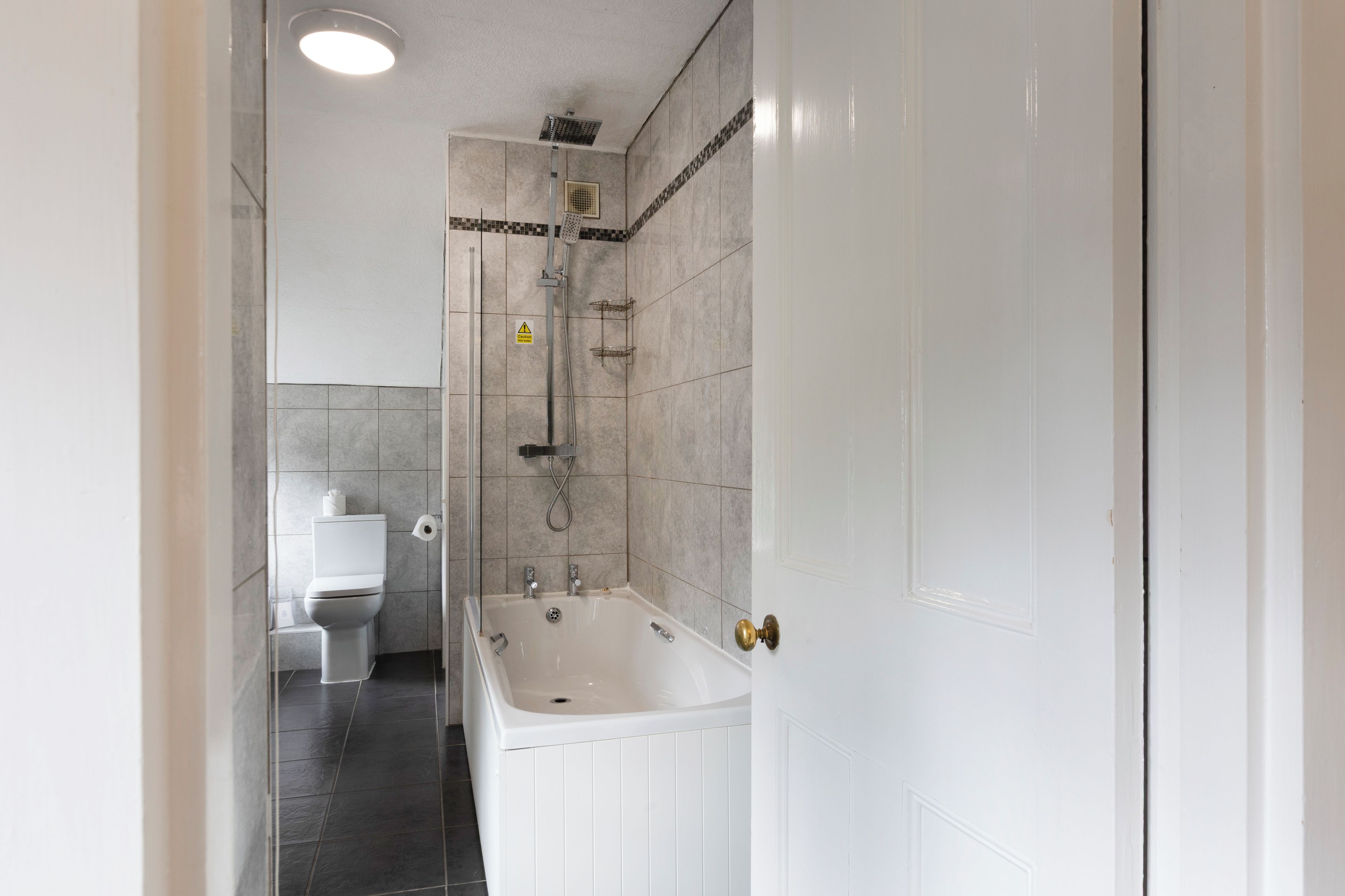 Un baño con bañera, inodoro y zona de ducha.