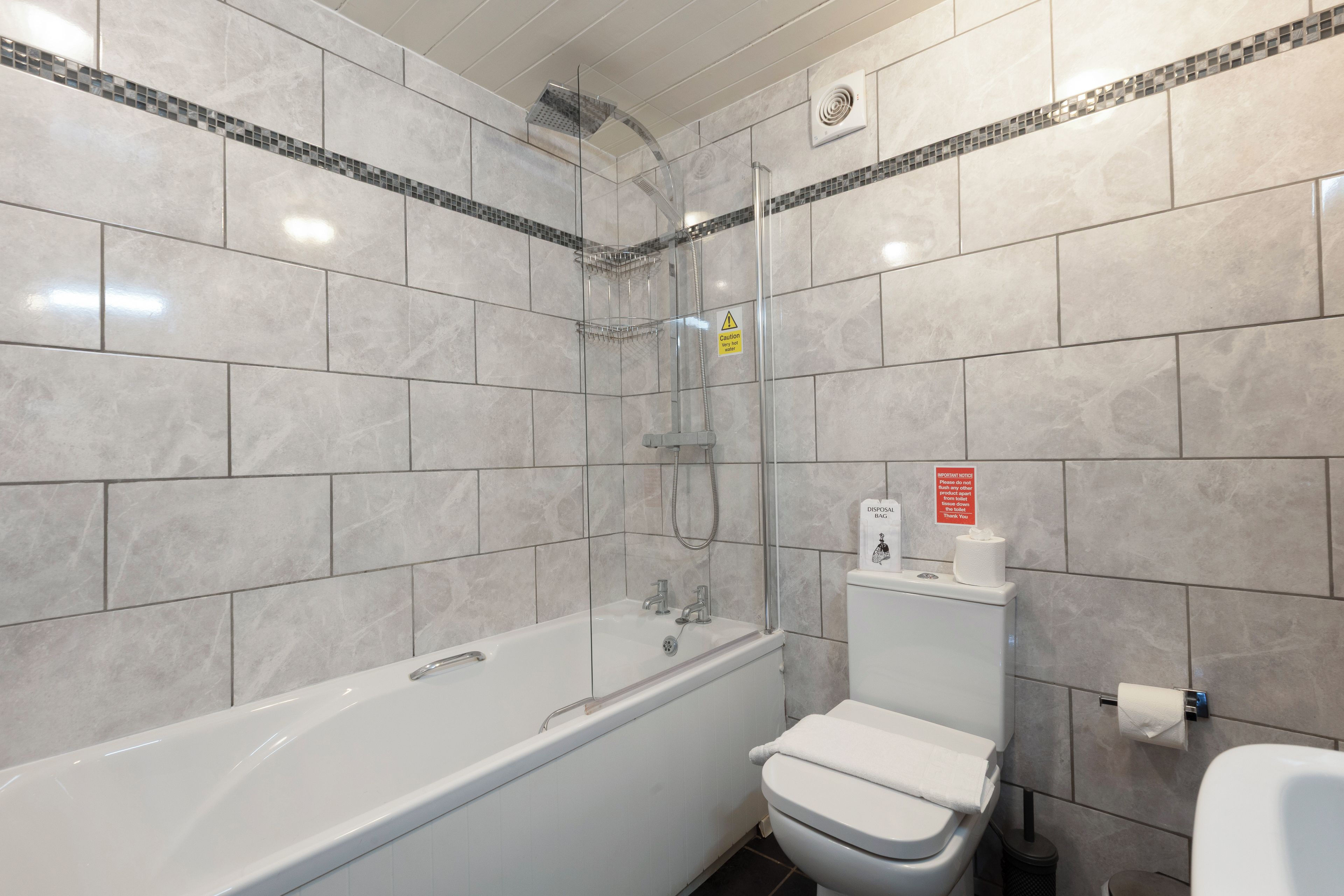 Un baño con bañera, inodoro y ducha.