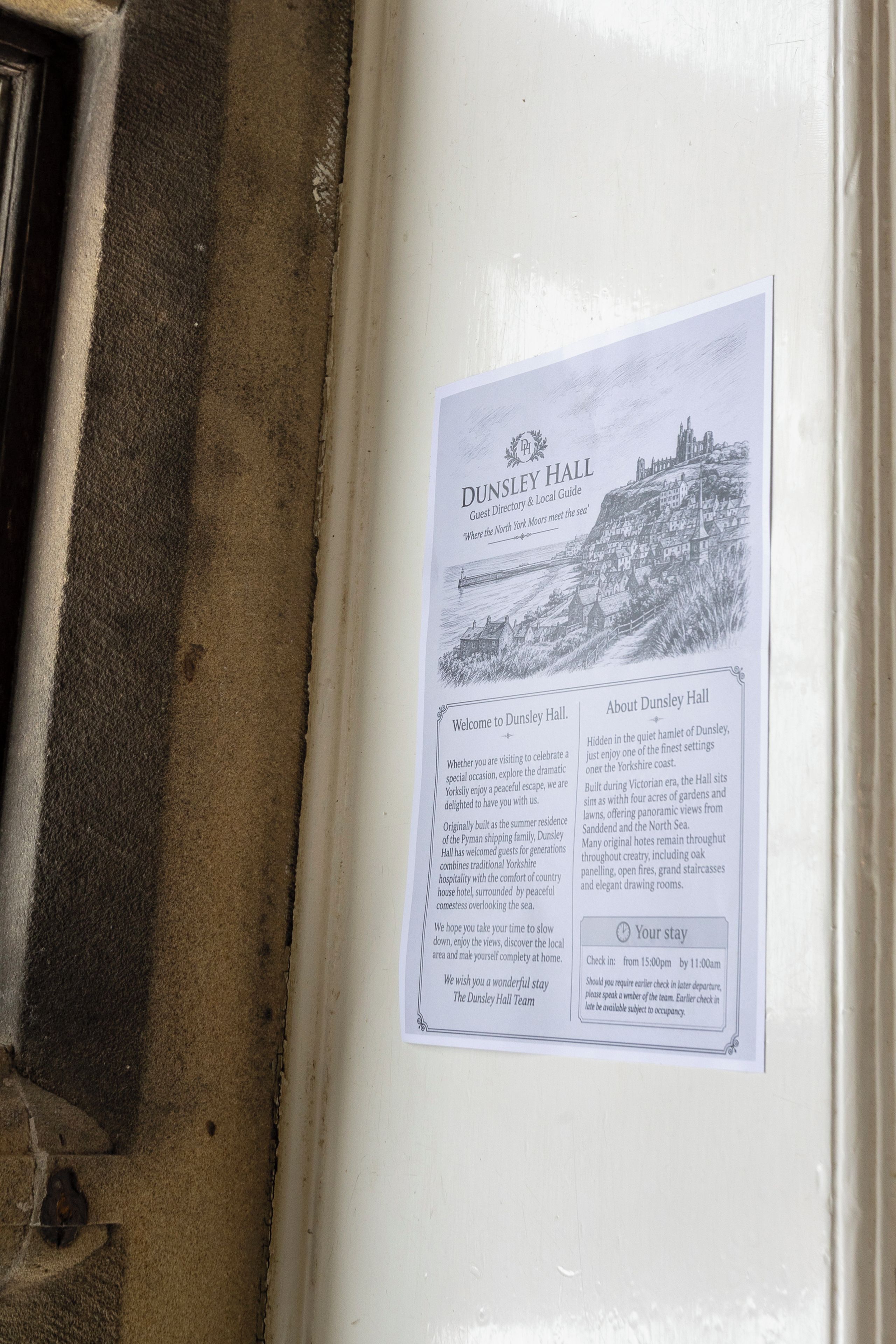 A guest information board for Dunsley Hall, detailing its history, amenities, and check-in times.