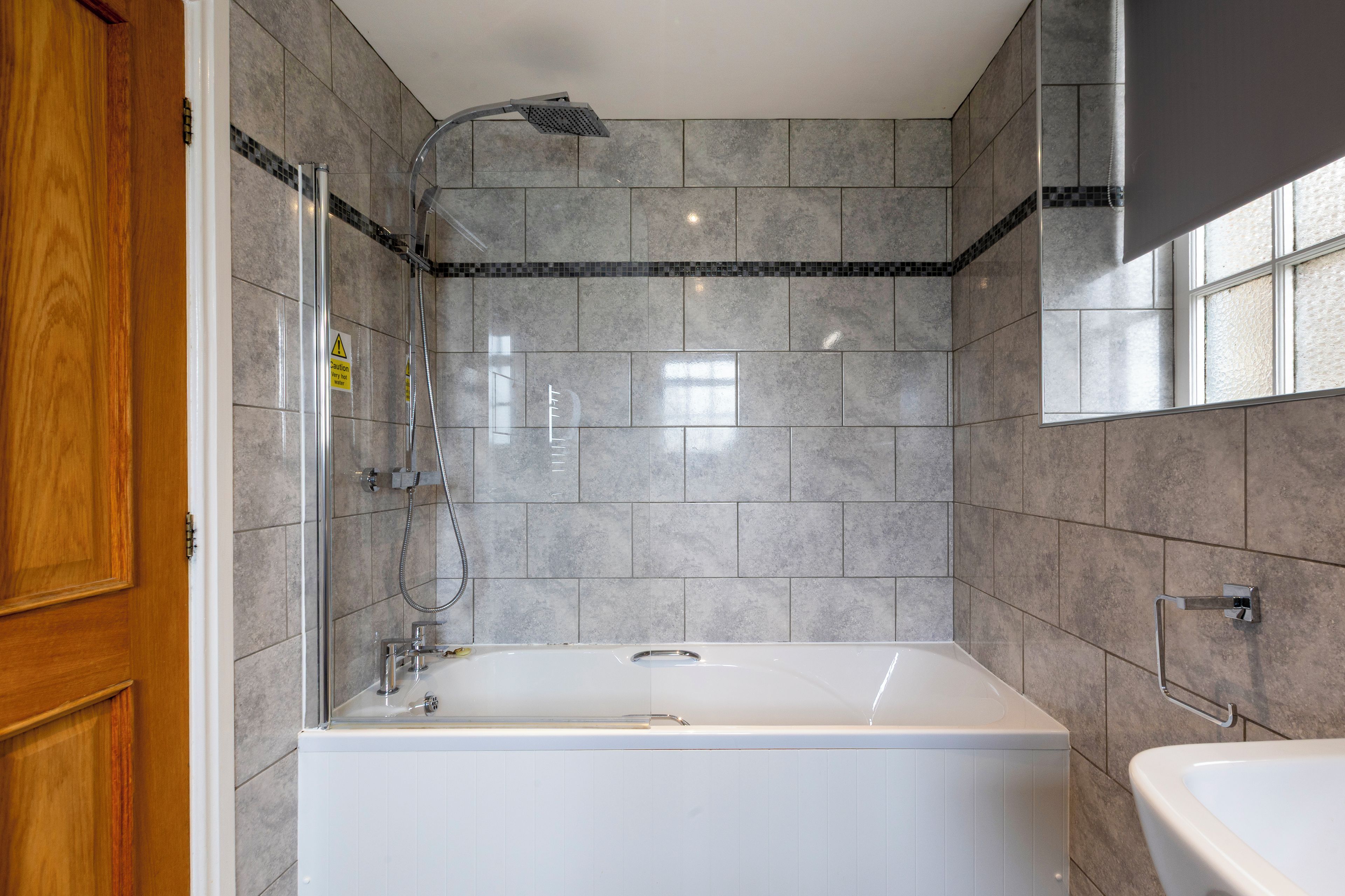 Un baño con bañera, ducha y lavamanos.