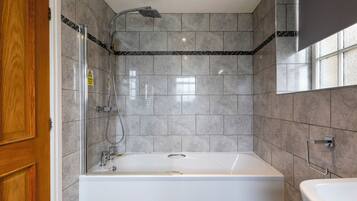 Un baño con bañera, ducha y lavamanos.