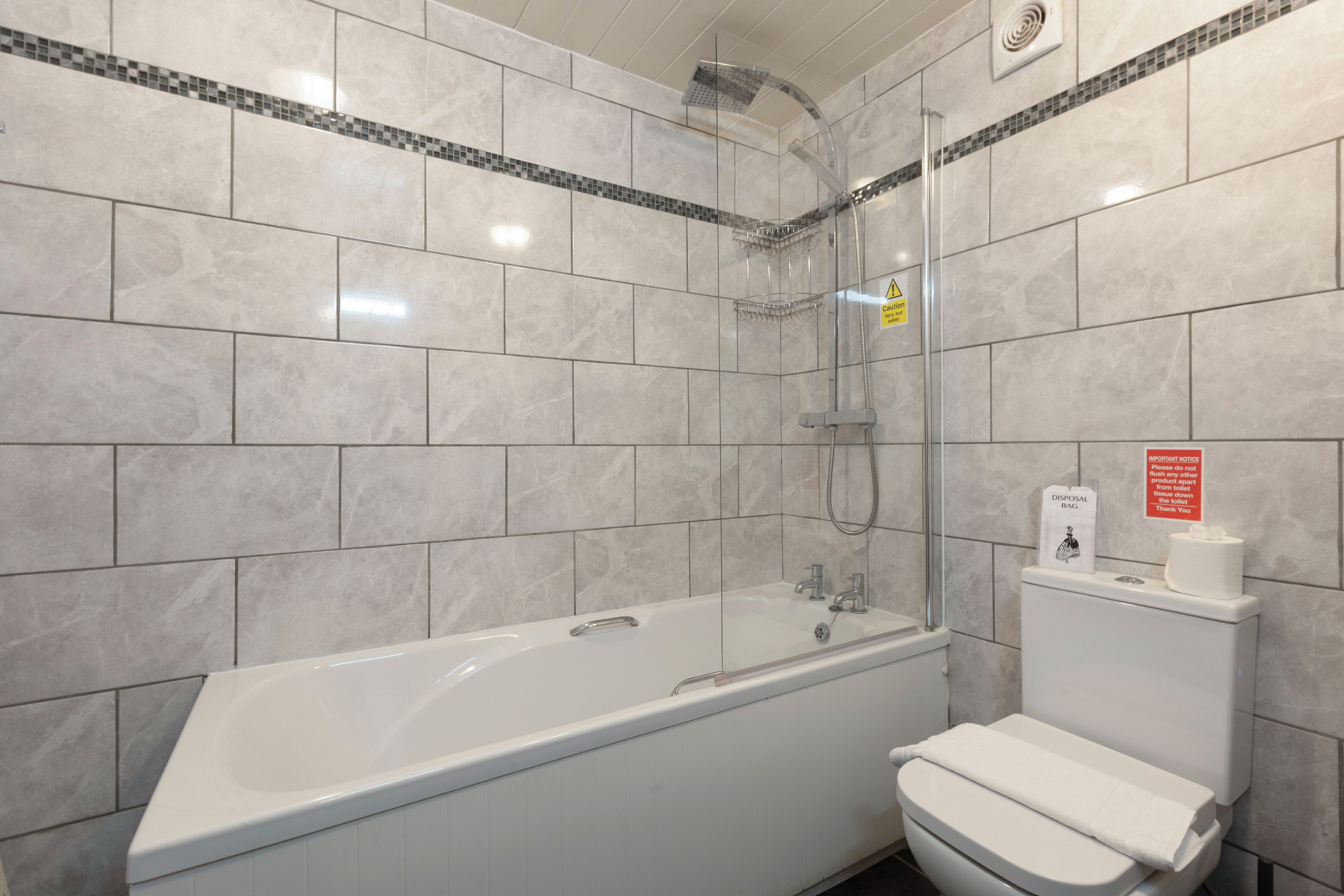 Une salle de bain moderne équipée d’une baignoire, d’une douche et de toilettes.
