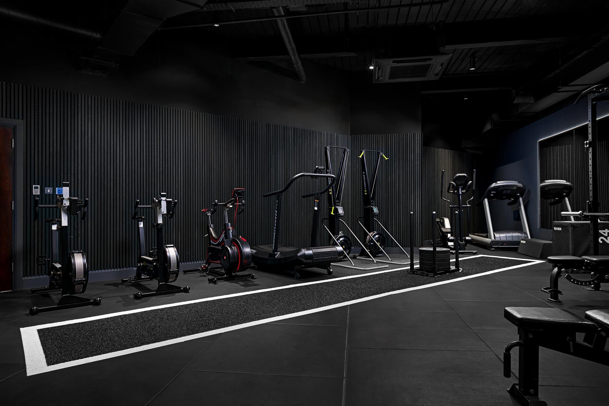 A gym with various exercise equipment, including treadmills, stationary bikes, and weight machines.