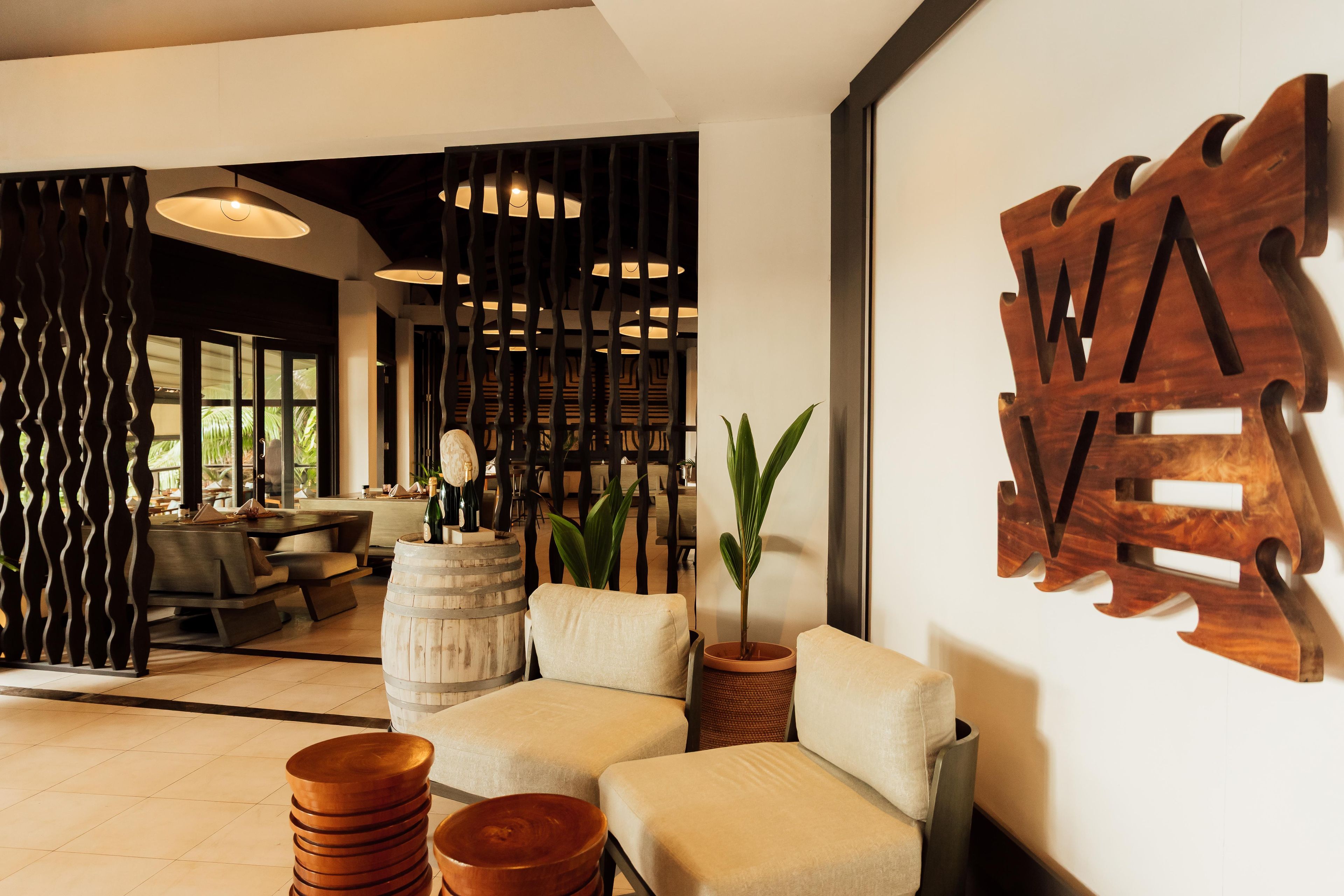 A modern interior with a sofa, a wooden decorative piece, and a plant.