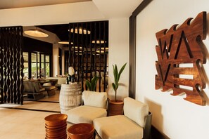 Un intérieur moderne avec un canapé, un élément décoratif en bois et une plante.
