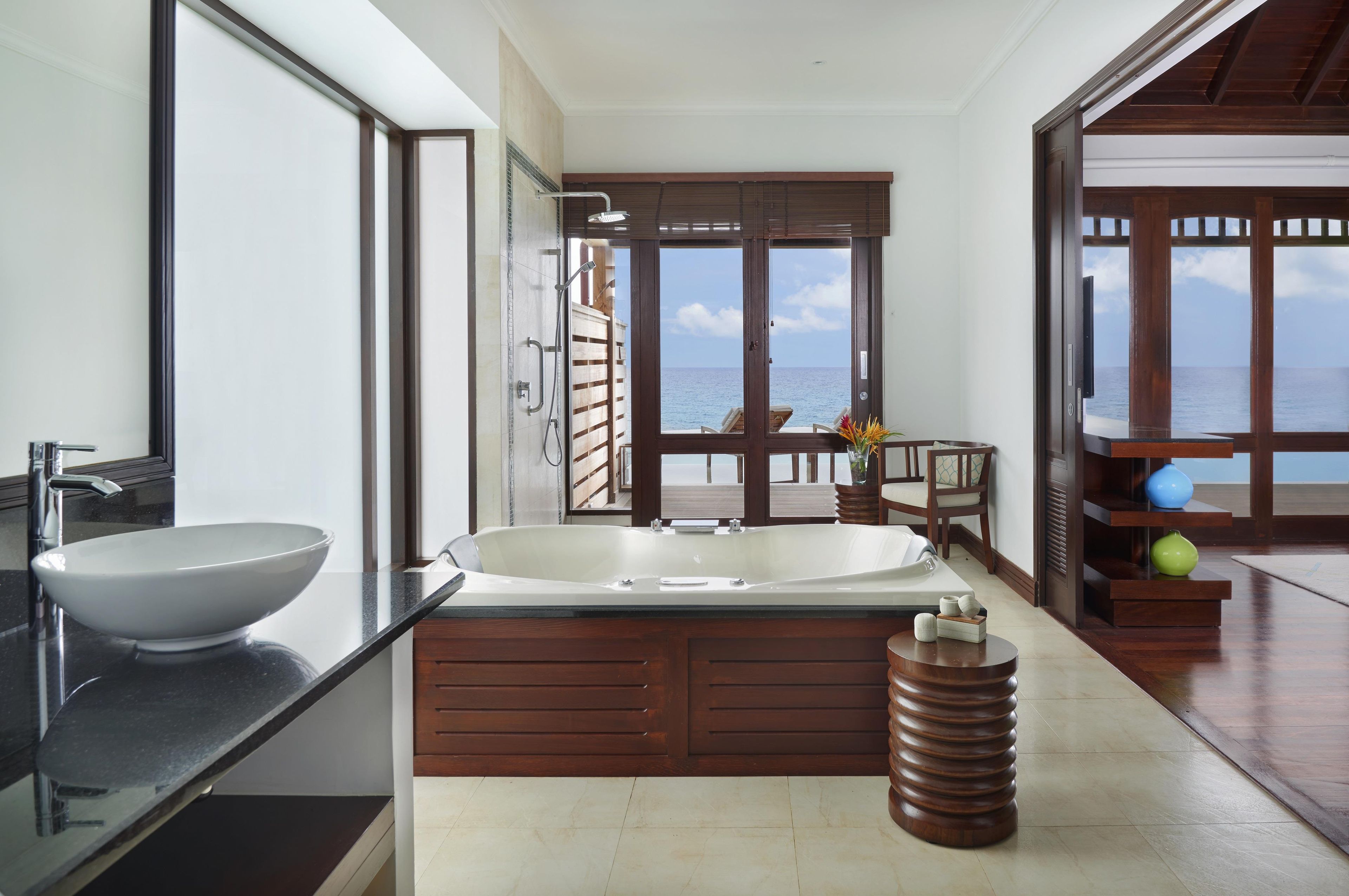 A modern bathroom with a large bathtub, a vessel sink, and a shower area.