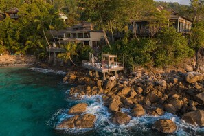 Une propriété située sur la côte, comprenant plusieurs bâtiments, un littoral rocheux et offrant une vue dégagée sur l’océan.