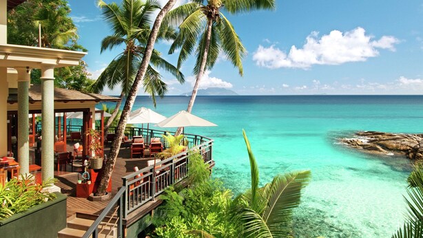 Ein Resort mit Außenbereich, Palmen und Meerblick.