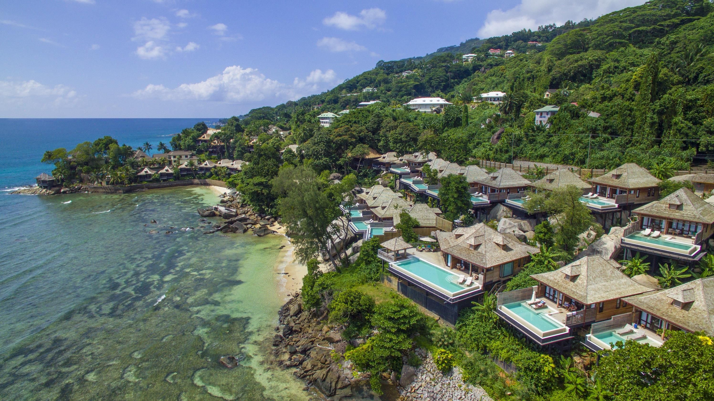 A coastal resort with overwater bungalows, clear turquoise waters, and lush greenery.