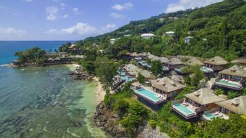 A coastal resort with overwater bungalows, clear turquoise waters, and lush greenery.