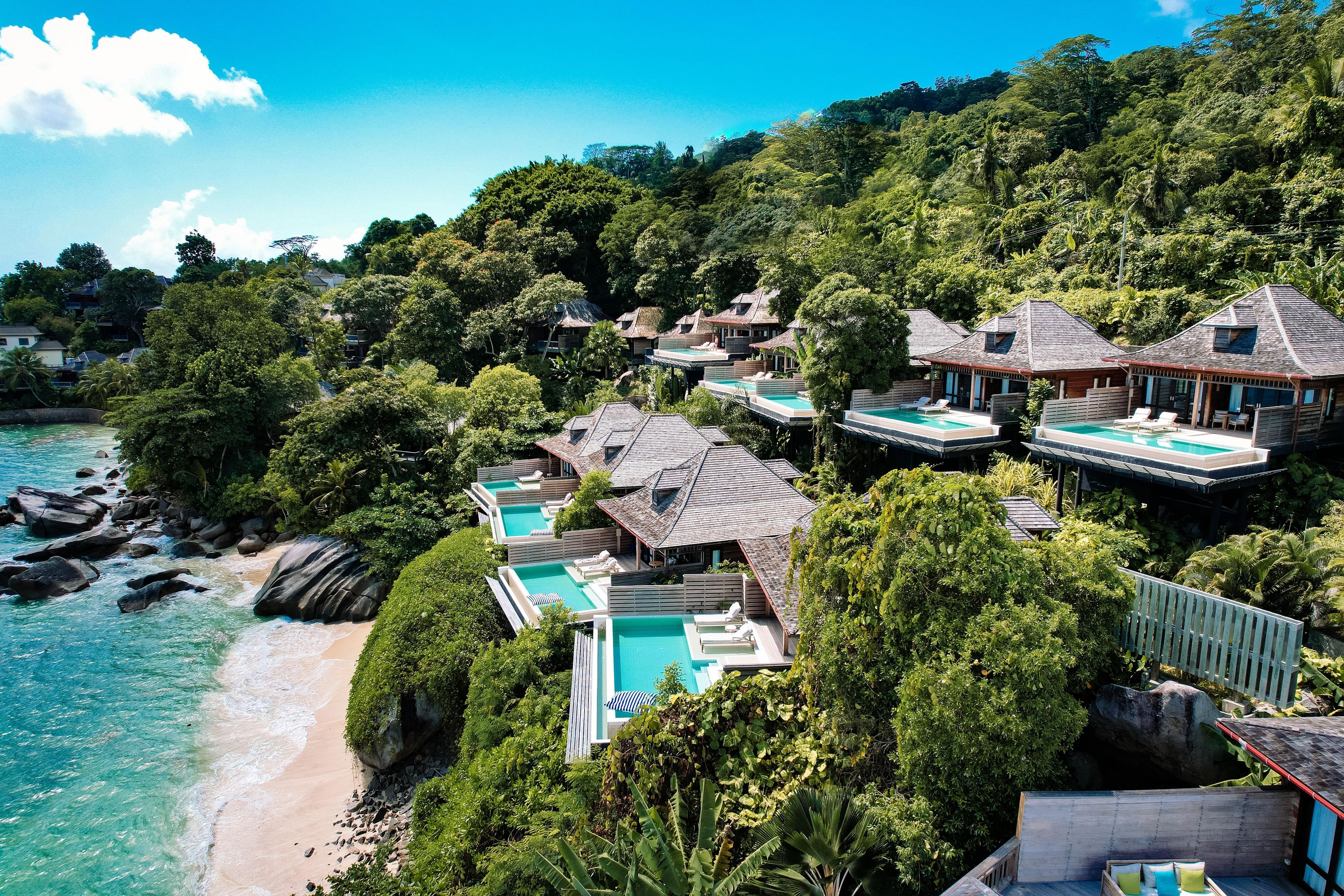A resort with multiple swimming pools, beachfront, and lush greenery.
