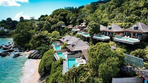 Ein Resort mit mehreren Bungalows auf Stelzen, jedes mit eigenem Pool und direktem Zugang zum Meer.