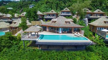A resort with multiple bungalow-style buildings, a central pool area, and lush greenery surrounding the property.