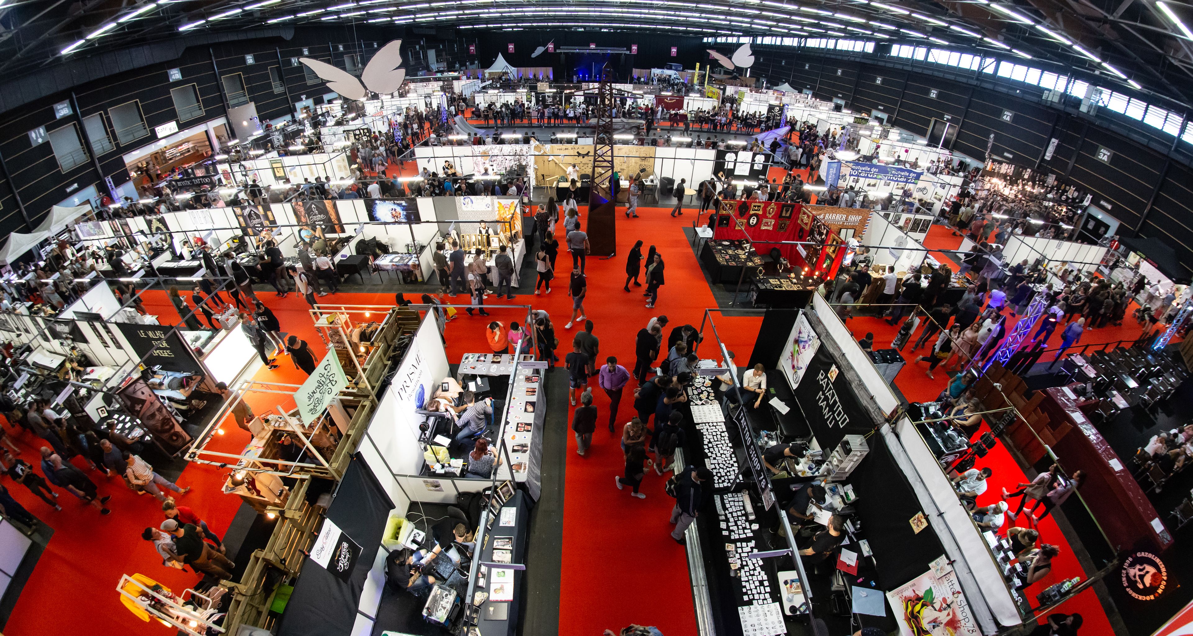 A large indoor exhibition hall with multiple booths and attendees.