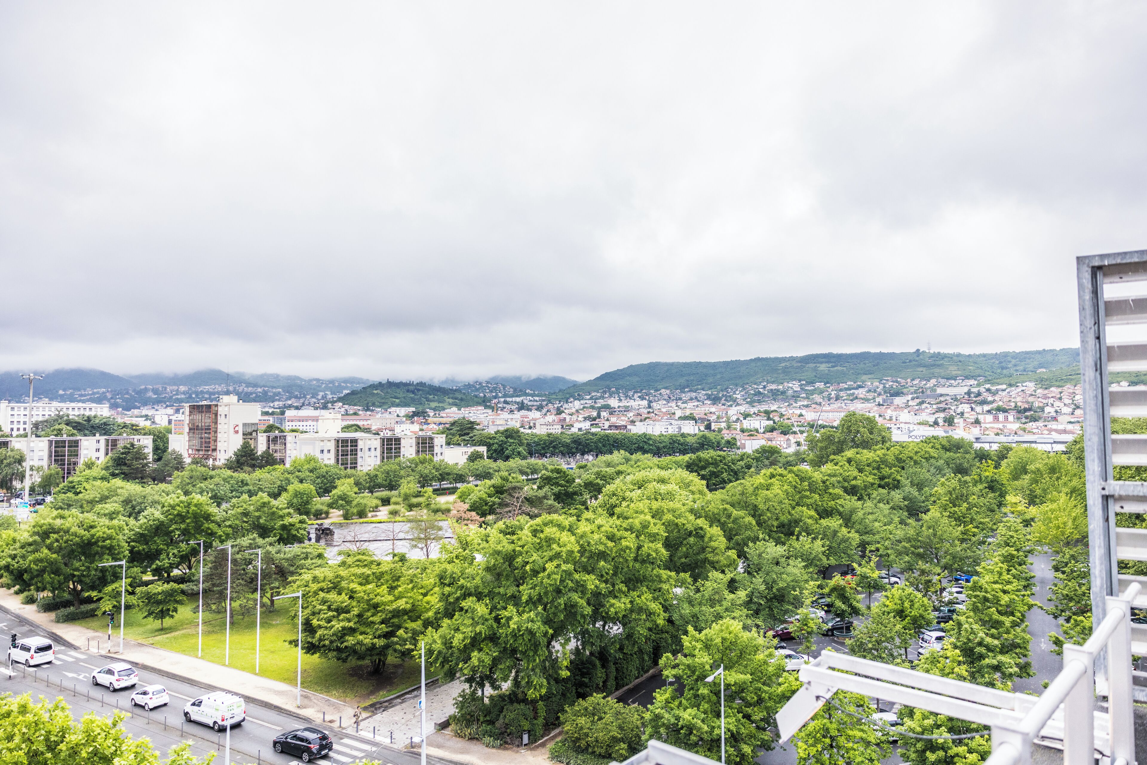 Une vue urbaine comprenant des bâtiments, des arbres et une route.