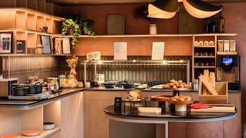 A modern kitchen with a central island, various kitchen appliances, and a variety of food items displayed on the counter.