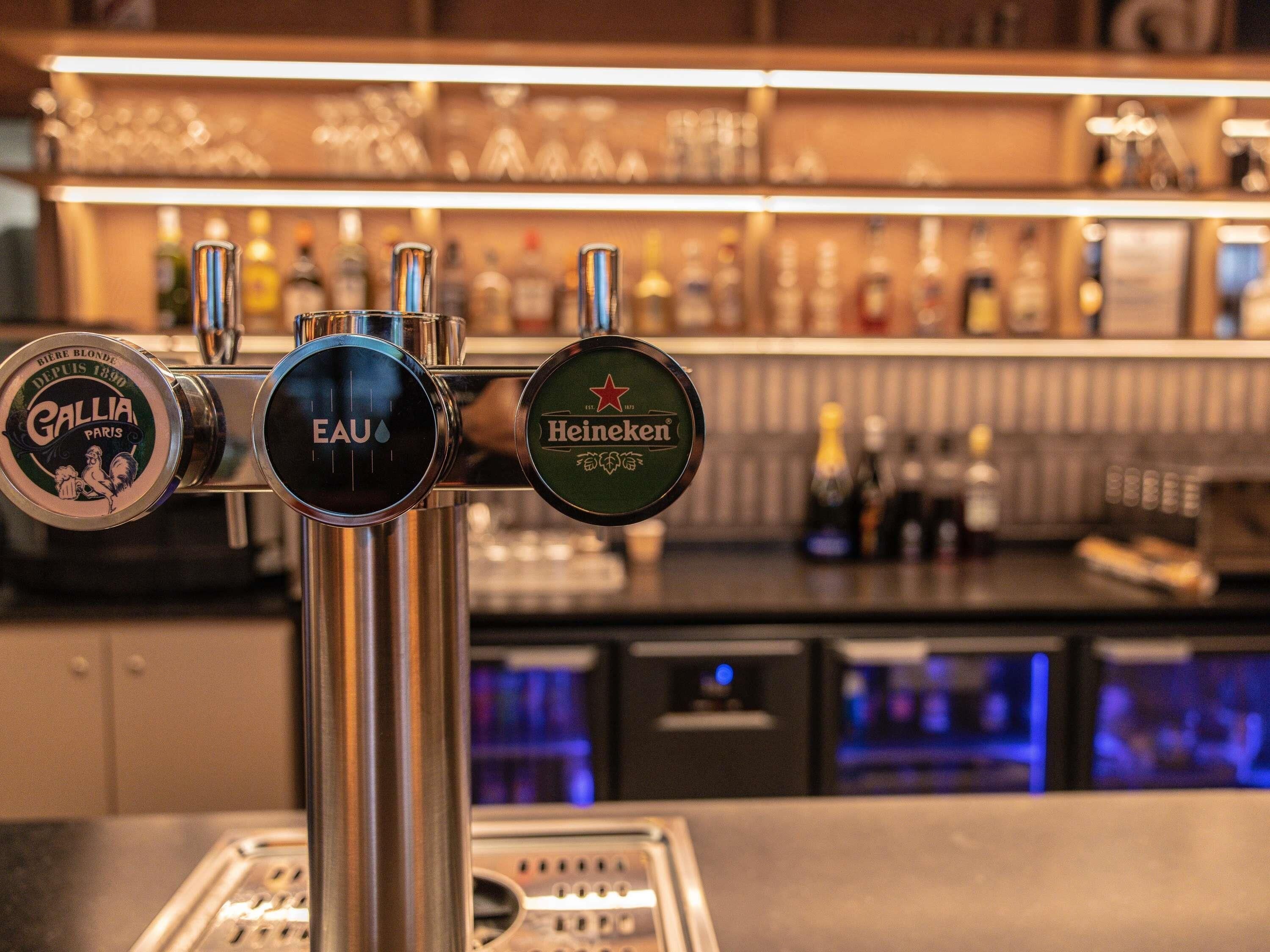 A bar tap with three beer brands: Gallia, Eau, and Heineken.