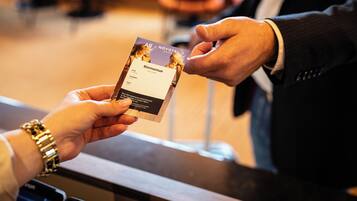 A person handing over a welcome card to another individual.