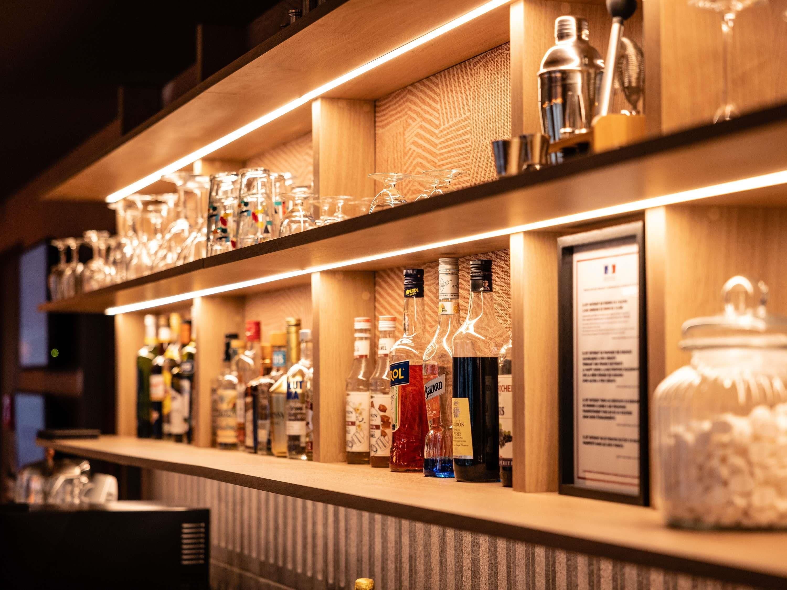 A bar area with shelves of liquor bottles and glasses.