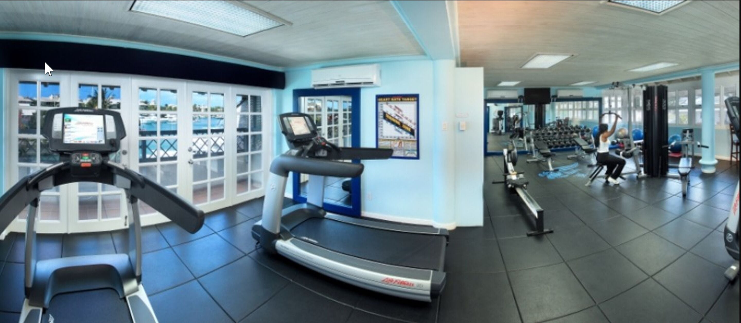Ein Fitnessstudio mit Laufbändern, Gewichten und Trainingsgeräten.