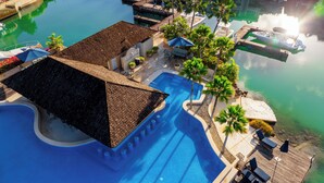 Un resort con una amplia piscina, una terraza de madera y una zona de embarcadero.