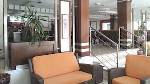 A lobby with wicker furniture, a staircase, and a reception area. - Marion (Polis)