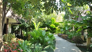 A garden pathway with various plants and a tiled walkway. - Laluna Hotel & Resort (Chiang Rai)