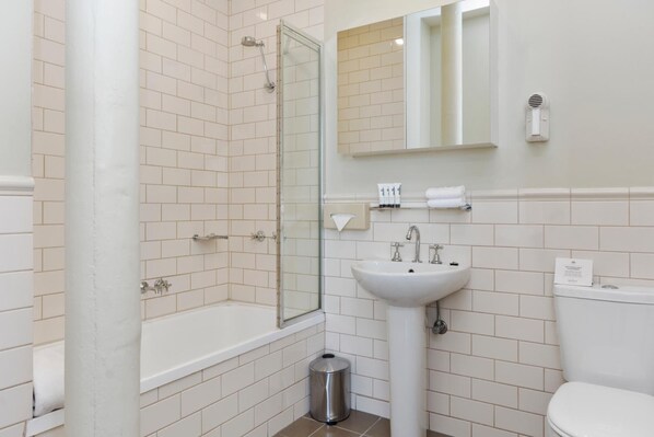 A modern bathroom with a glass shower enclosure, a white sink, and a toilet. - Launceston Central Apartment Hotel (Launceston)
