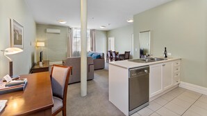 Un espacio habitable compacto con comedor, kitchenette y sofá.