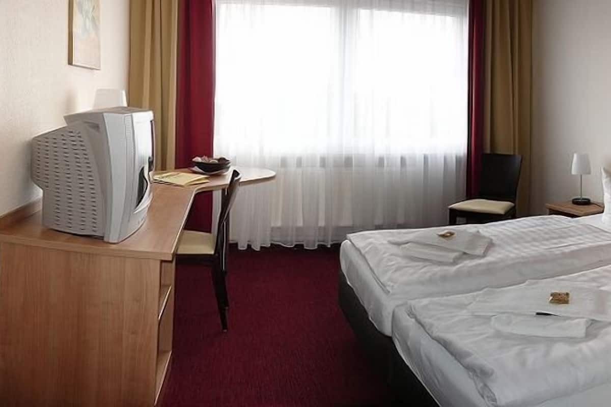 Ropa de cama hipoalergénica y caja de seguridad en la habitación