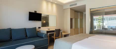 Une chambre d’hôtel moderne équipée d’un lit, d’un bureau, d’un canapé et d’une télévision.